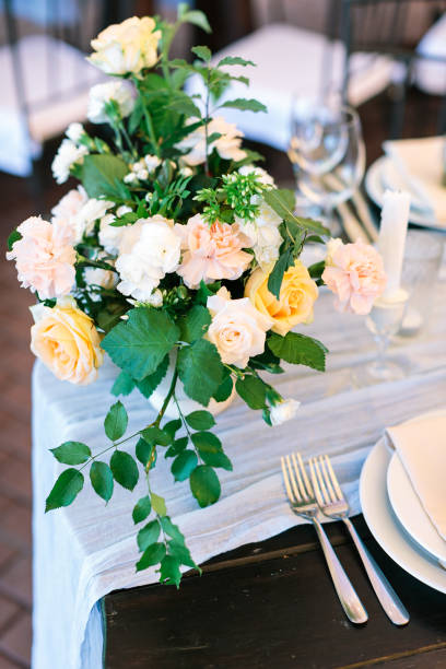 istock Vertical frame festive setting of the wedding table for seating guests at the welcome dinner with a central composition of flowers, candlesticks 1225271155