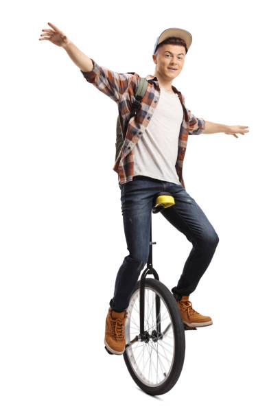 молодой студент-мужчина жонглирует на одноколесном велосипеде - unicycle стоковые фото и изображения