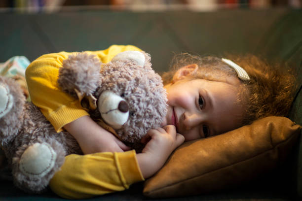 adorable little girl embracing her toy and smiling at camera.