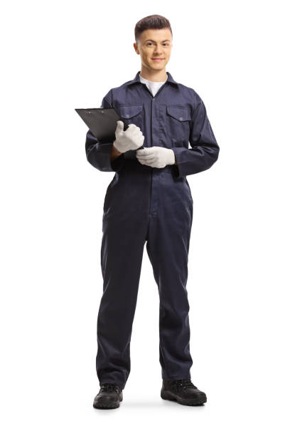 istock Young male worker in an overall uniform holding a clipboard with a document 1225273123