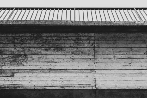 Underside of a concrete footbridge, finished with the imprint of timber planks.  A metal hand rail tops the bridge.  Belfast, Northern Ireland.