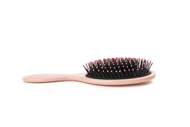 pink colored hairbrush isolated on a white background. comb for hairstyle and hygiene care. stock photo
