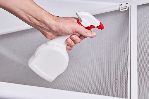 cleaning and washing dusty mosquito net screen for window. housework concept.