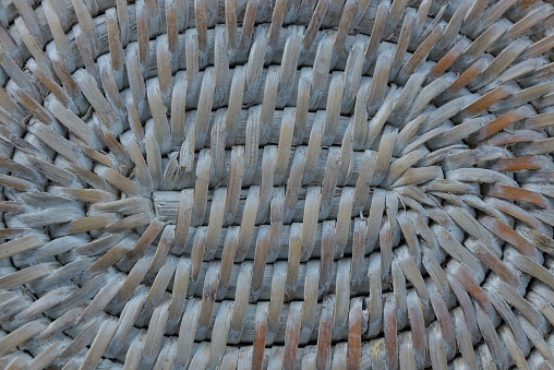 gray wooden background of a piece of wicker basket