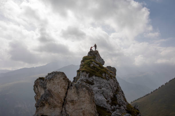 One mountaineer gives the other a helping hand to the peak