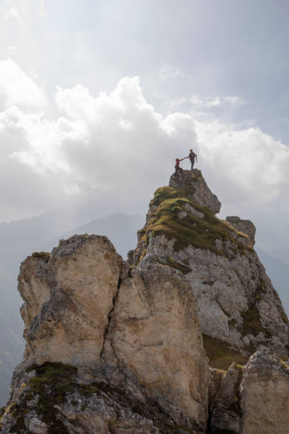 One mountaineer gives the other a helping hand to the peak