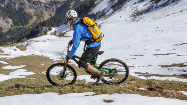 istock Mountain biker prepares to ride down snowy mountain ridge 1225280735