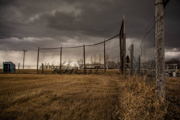 Small Town Baseball Diamond in Spring An old, small town baseball diamond in desperate need of repair stands on the prairie in spring. old baseball stock pictures, royalty-free photos & images