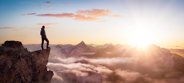 Magical Fantasy Adventure Composite of Man Hiking en la cima de una montaña rocosa photo