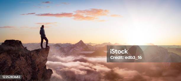 Magical Fantasy Adventure Composite Of Man Hiking On Top Of A Rocky Mountain Stock Photo - Download Image Now