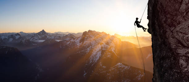 silhouette rappelling de cliff. - rápel fotografías e imágenes de stock