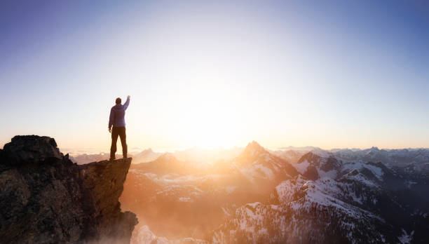 istock Fantasy Adventure Composite with a Man on top of a Mountain Cliff 1225284583