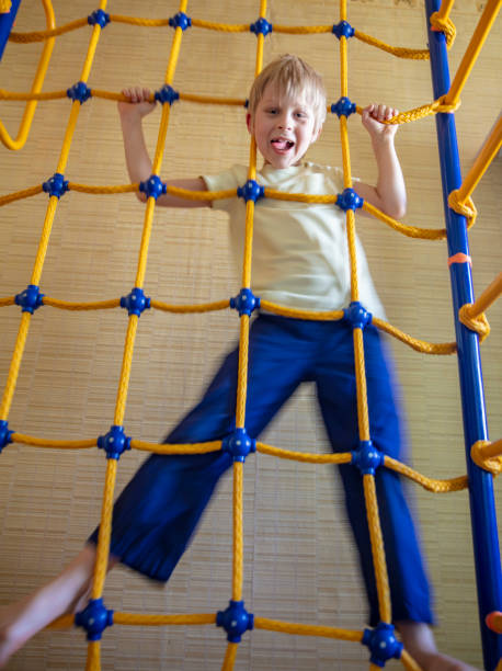 istock Boy hangs on a rope ladder in a sports complex 1225290330