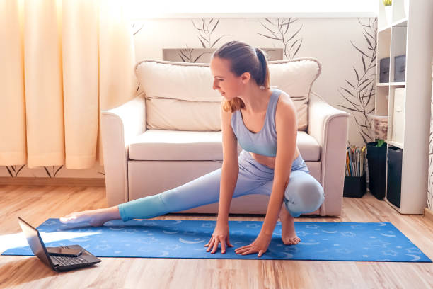 istock girl doing yoga at home online. 1225290496