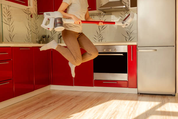 istock Woman jump with wireless vacuum cleaner. 1225290502