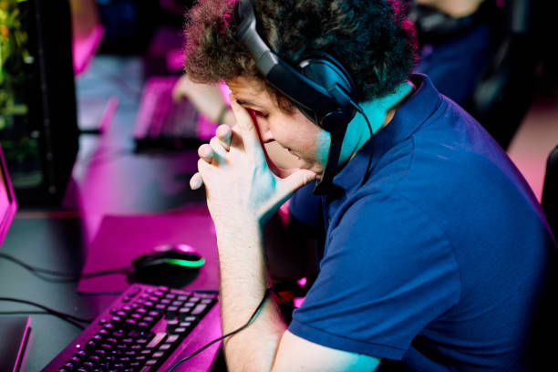 istock Tense or worried young man in headset touching face while bending over keyboard 1225294270