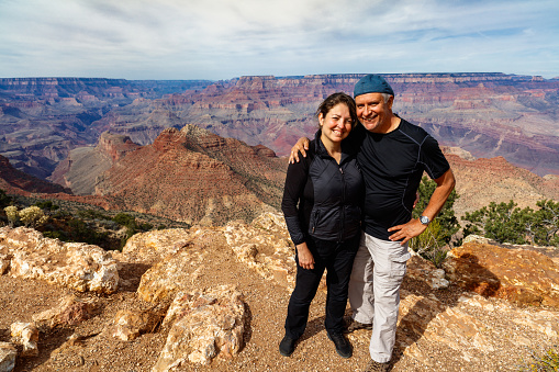 Attractive couple enjoying the beautiful Grand Canyon National Park along the South Rim in Arizona.