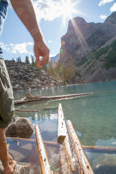 istock Man balances rocks submerged in alpine lake 1225294417