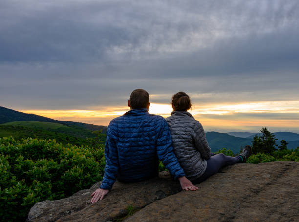 pareja mira hacia fuera sobre puesta de sol cayendo en blue ridge - blue ridge mountains mountain range north carolina tennessee fotografías e imágenes de stock