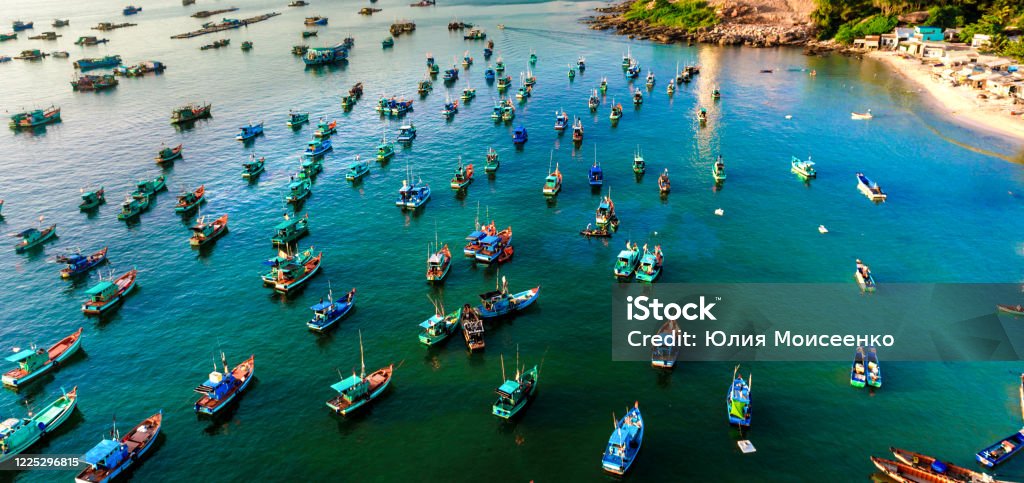 many multi-colored, beautiful ships in the sea. view from above many multi-colored, beautiful boats in the sea. there are many floating boats in turquoise water, panoramic shots from the air. Antenna - Aerial Stock Photo