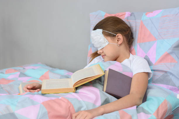 istock The sick girl fell asleep lying in bed and pulled the mask over her face 1225298486