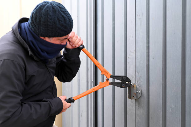 Burglar breaking into a garage Burglar breaking into garage using bolt cutters  to cut door locker. bolt cutter stock pictures, royalty-free photos & images