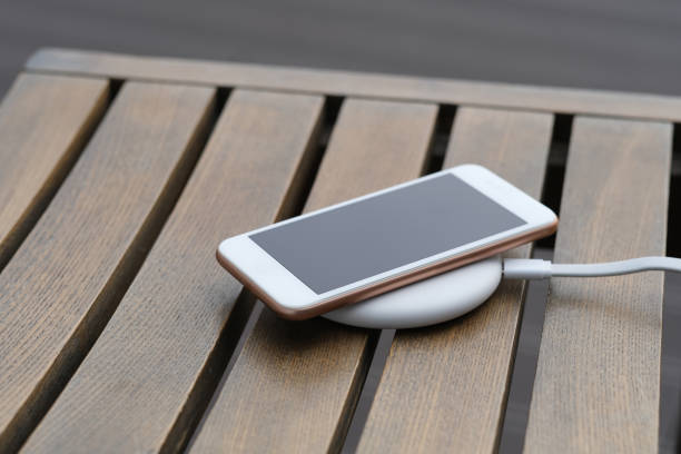 istock close up one smartphone on wireless charger on wooden table. 1225316317