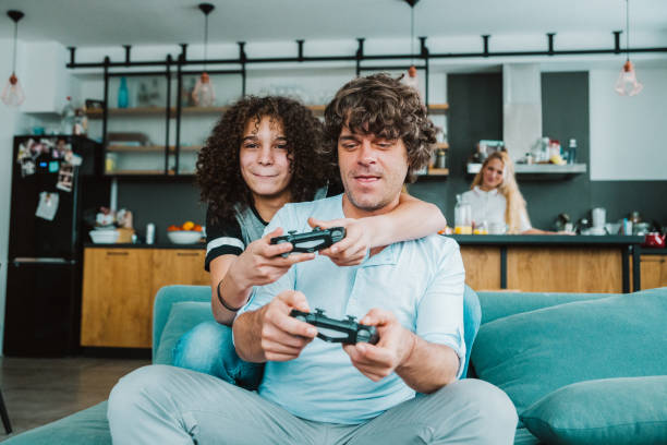 istock Father and son playing digital games at home 1225317983