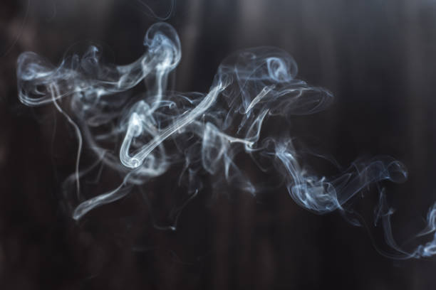 istock Image of backlit puffs of smoke, on a dark background. 1225318897