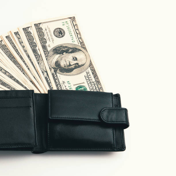 istock A black wallet with dollars in it on a white background. 1225319957