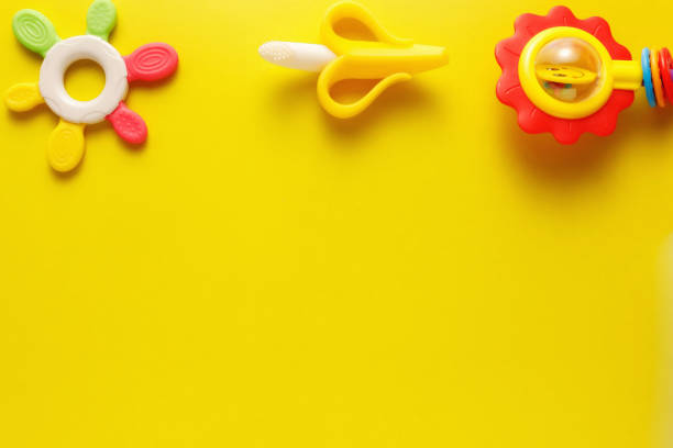 istock Colorful and various plastic toys for babies on a yellow background. Layout. Empty space for the text. Minimalism 1225325513