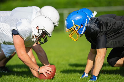 American Football Players lining up head to head, taking their positions. American Football Player and Cheerleader Series.