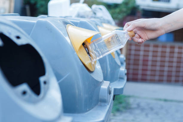 istock Closeup woman hand throwing empty plastic bottle in recycling bin. isolated outdoors background. 1225328444