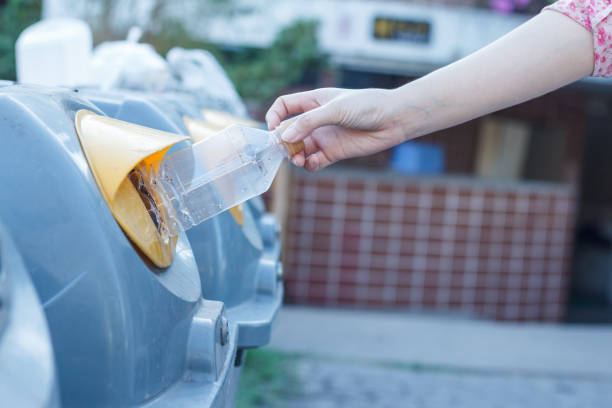 istock Closeup woman hand throwing empty plastic bottle in recycling bin. isolated outdoors background. 1225328501