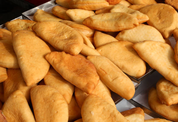 many mouth-watering food called stuffed panzerotti with mozzarella and tomato on sale in the Italian street food stall