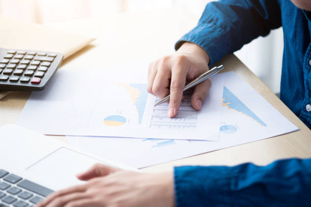 istock Businessman is inspecting the business reports graphs and typing on computer keyboard to audit the financial reports. Analyzing the revenue and auditing the budget concept. 1225329899