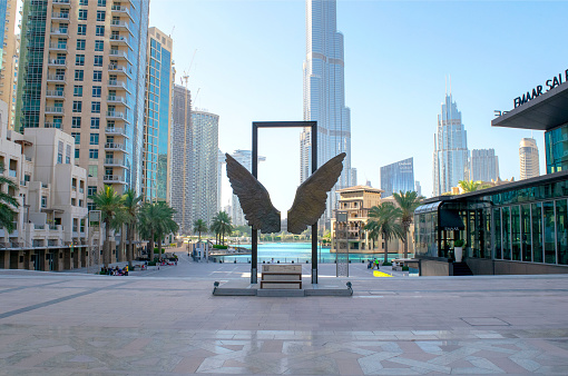 Dubai / UAE - May 12, 2020: View of Souk al Bahar, Dubai fountain with Burj Khalifa and park. Beautiful view of Dubai downtown district with restaurants and souk. Wings of Mexico sculpture