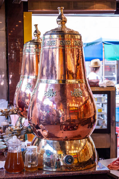 istock View on Large golden decoratuve samovar for prepare herbal beverage - relieving drink for eliminate toxicity.. Traditional asian medicine shop in Kuala Lumpur. Healthy lifestyle. Brass urns. 1225340025