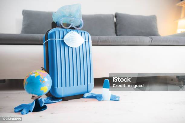 Travel Bag Suitcase With Earth Globe Gloves Mask And Head Protection From Viruses And Flu Influenza Tourist Traveling Canceled All Over The World 2020 Season Is Postponed Stock Photo - Download Image Now