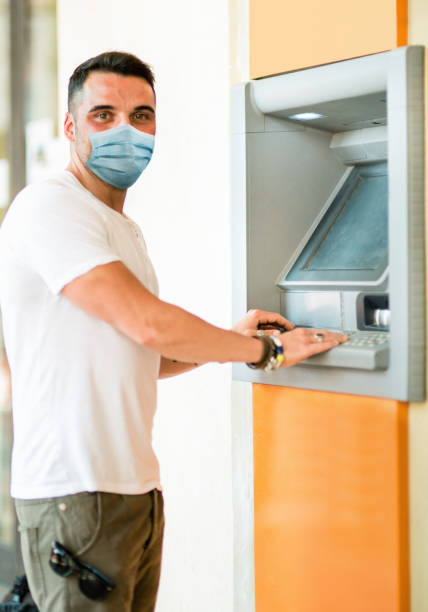 istock man at the ATM with face mask 1225344728