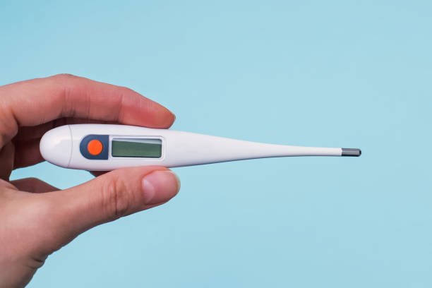 istock Hand holding a digital thermometer close-up 1225345697