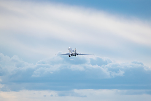 Business jet is taking off from with clouds on the background
