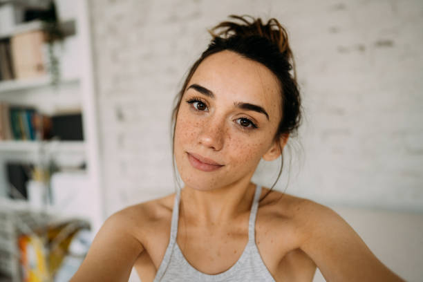 Proud of my freckles! Photo of a confident young woman in the living room of her apartment; embracing her natural beauty. freckle photos stock pictures, royalty-free photos & images