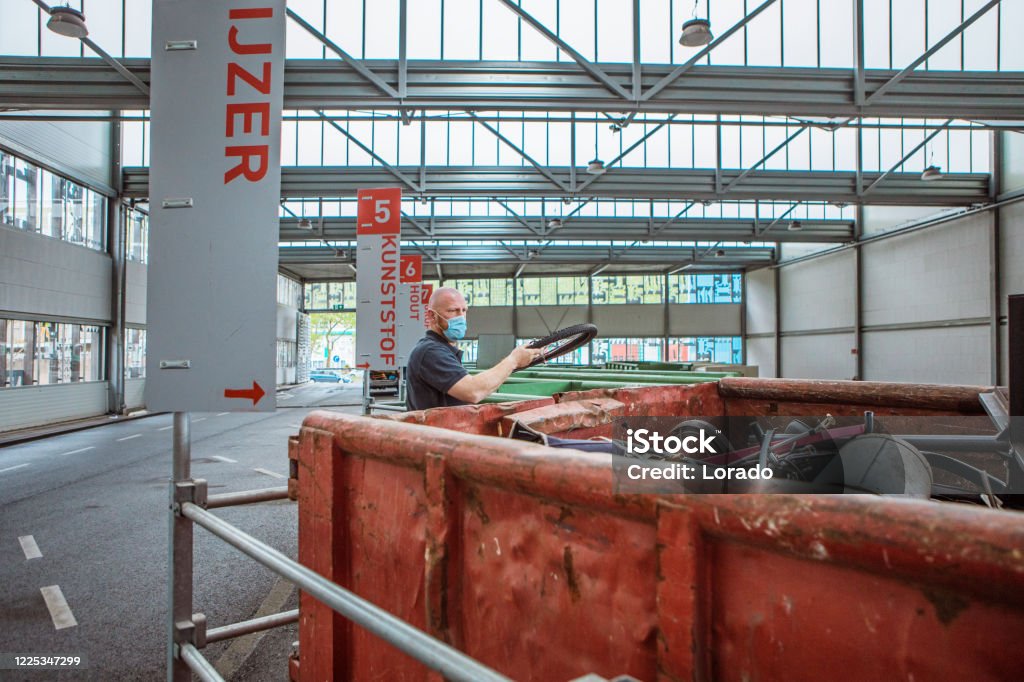Mens bij een metaalrecyclingcentrum tijdens coronavirusuitbarsting - Royalty-free Recycling Stockfoto