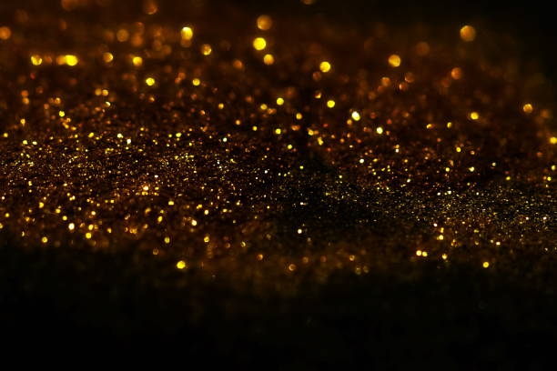 istock golden sparkles on black background. Festive, X-mas backdrop. Copy space 1225347929