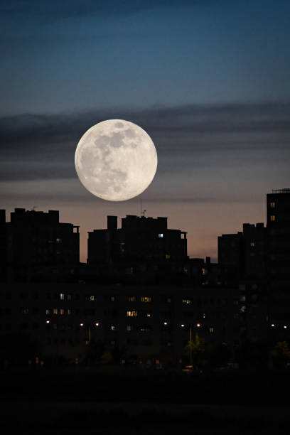istock Urban dusk, with a full moon between buildings 1225348152