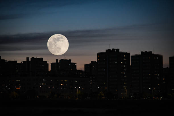 istock Urban dusk, with a full moon between buildings 1225348156