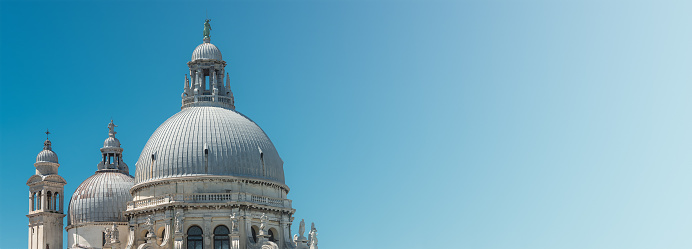 Panoramic view of Basilica di Santa Maria della Salute as a banner with gradient natural background, blue sky and sunny day, Venice, Italy
