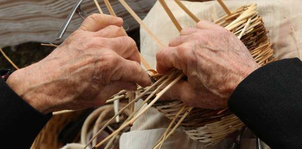 istock elderly craftsman with gnarled fingers when creating a basket ma 1225352844