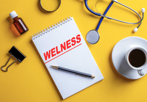 istock The word wellness is written in a white notebook on a yellow background. 1225353722